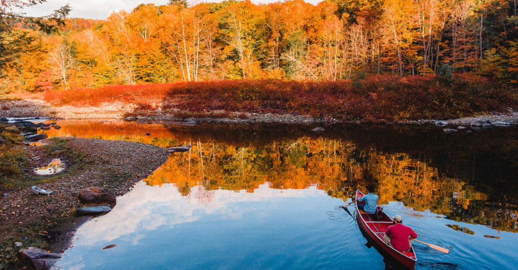Canoe on river with fall trees